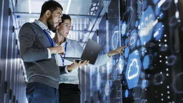 System engineers working in a high-tech data center, managing and optimizing IT infrastructure.